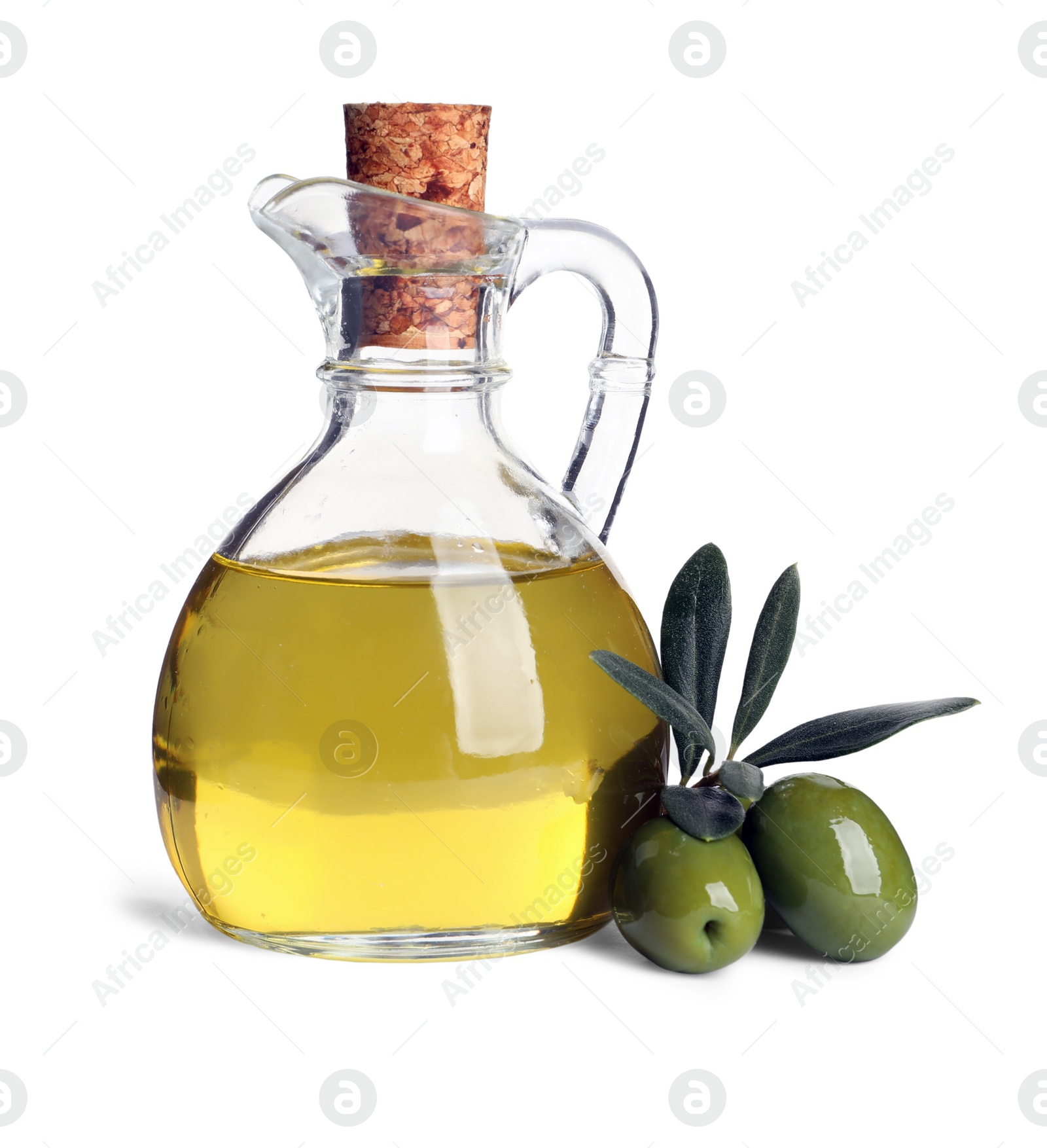 Photo of Glass jug of oil, ripe olives and leaves on white background