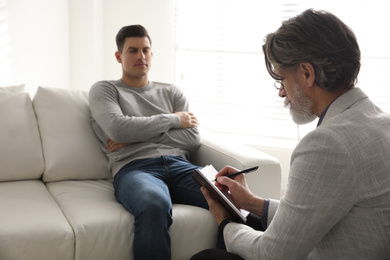 Photo of Psychotherapist and patient in office. Hypnotherapy session