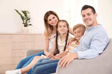 Happy family with cute children on sofa at home