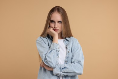 Photo of Portrait of resentful woman on beige background