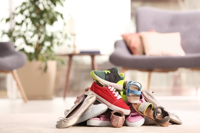 Photo of Heap of different shoes on floor in room. Space for text