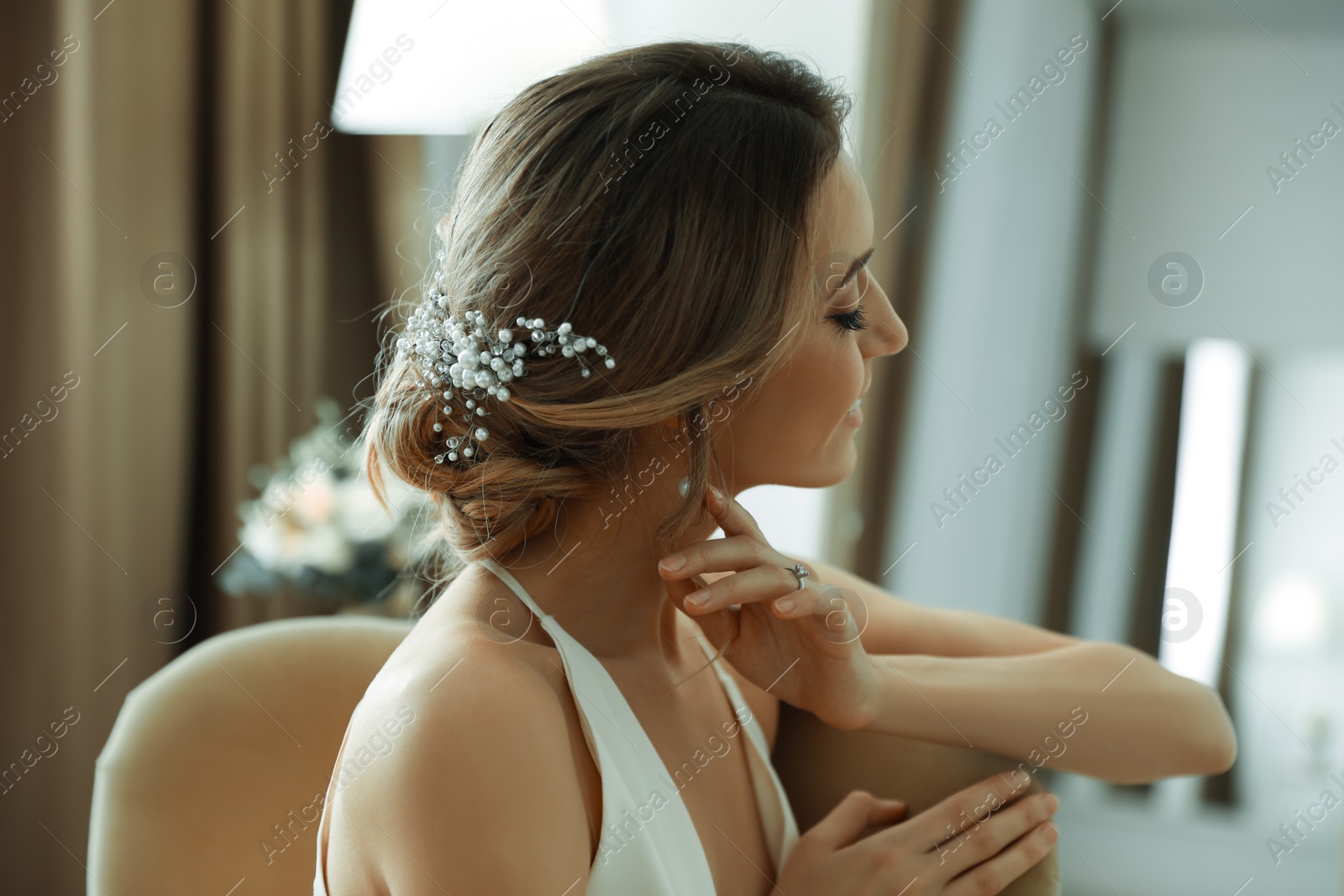 Photo of Young bride with elegant wedding hairstyle in room