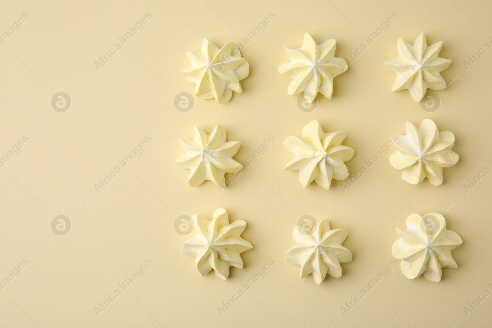 Photo of Delicious meringue cookies on beige background, flat lay. Space for text