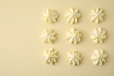 Photo of Delicious meringue cookies on beige background, flat lay. Space for text