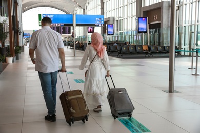 Photo of ISTANBUL, TURKEY - AUGUST 13, 2019: Couple with suitcases in new airport terminal