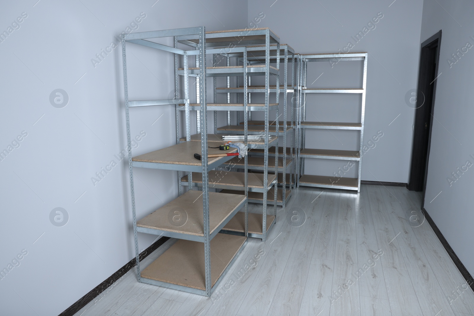 Photo of Office room with white walls and metal storage shelves