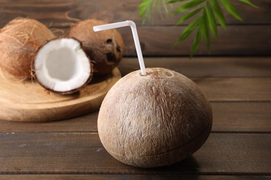 Photo of Coconut water. Fresh nut with straw on wooden table