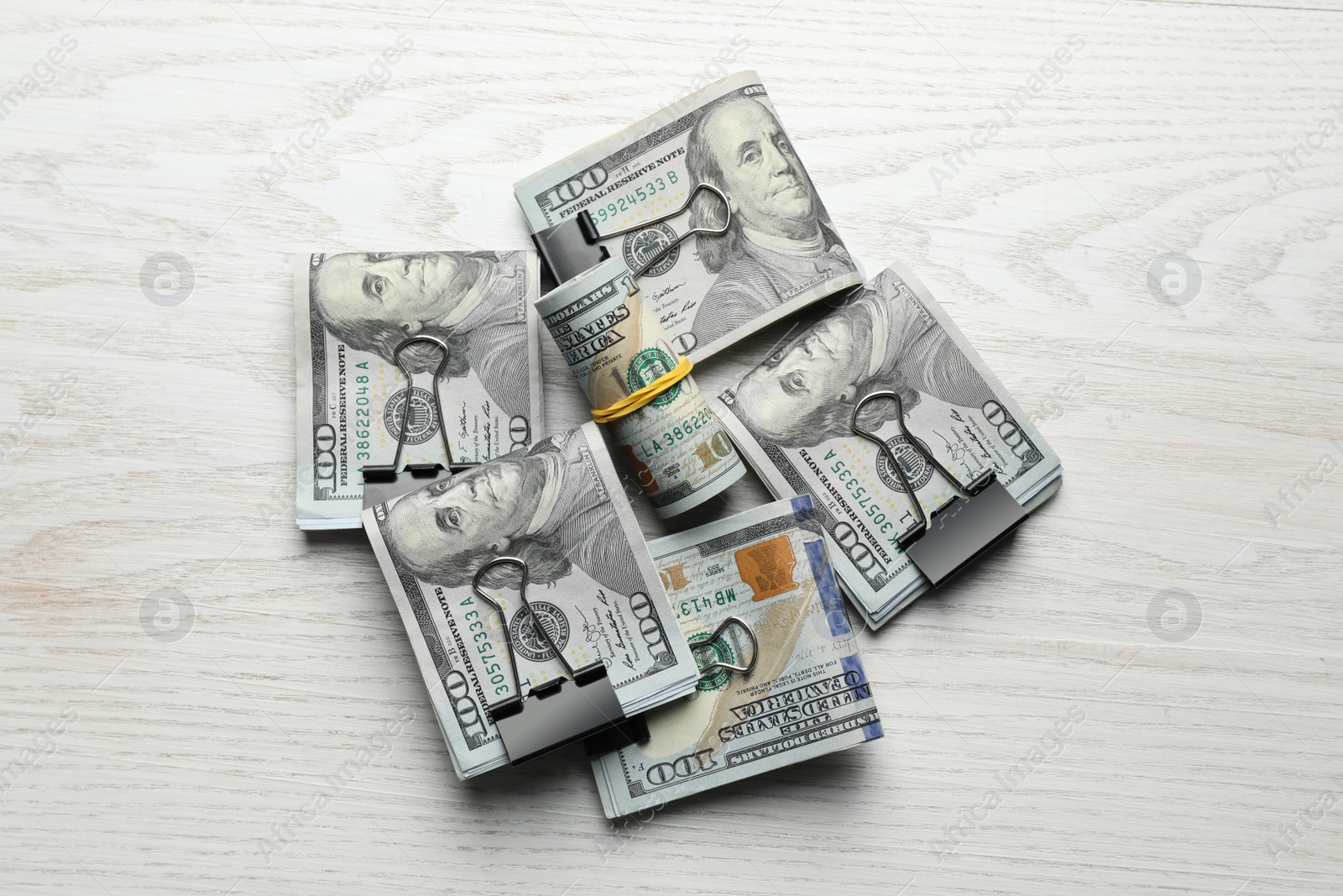 Photo of Many dollar banknotes on white wooden table, flat lay. American national currency