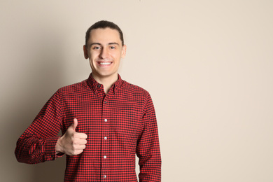 Photo of Portrait of happy young man on beige background. Space for text