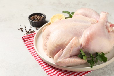 Photo of Fresh raw chicken with spices and lemon on light grey table