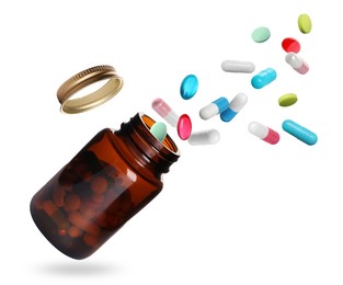 Many different colorful pills falling into bottle on white background