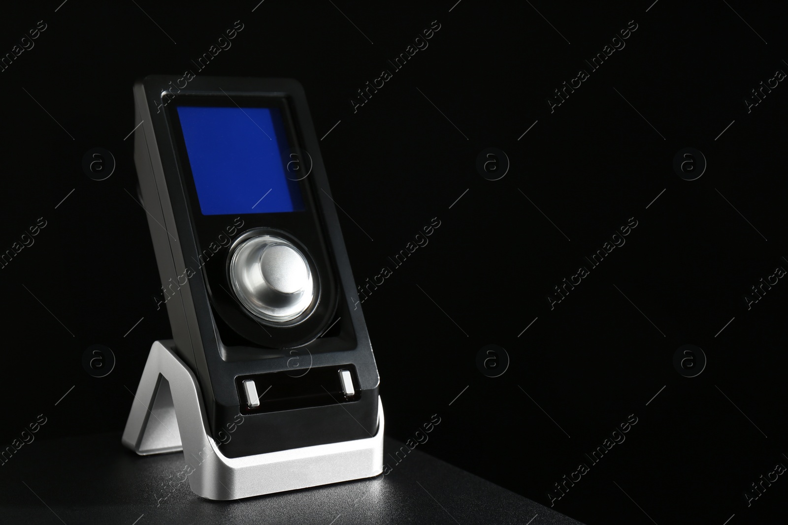 Photo of Remote control of audio speaker system on black table. Space for text