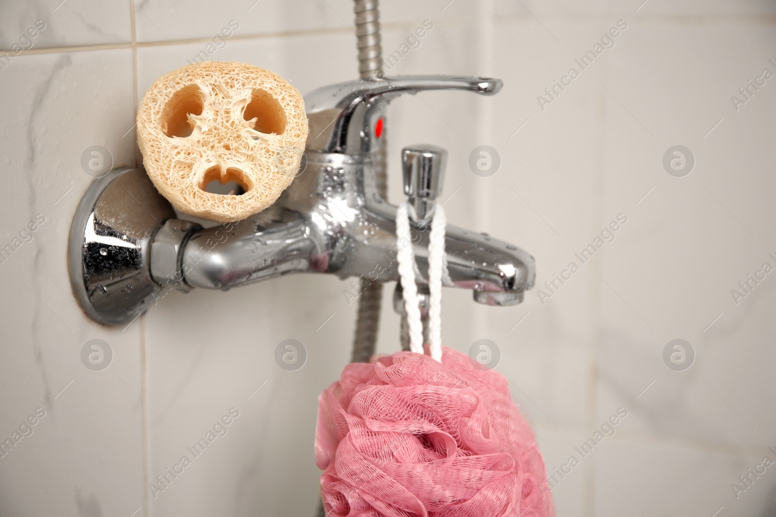 Photo of Different sponges on faucet in bathroom, closeup