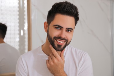 Photo of Handsome young man after shaving in bathroom