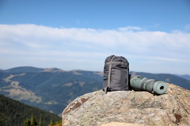 Photo of Sleeping bag and camping mat on mountain peak, space for text