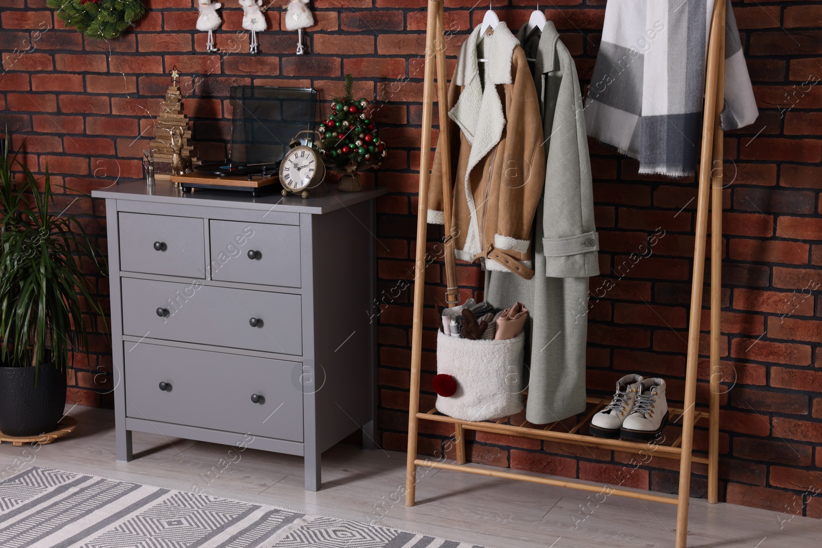 Photo of Modern hallway interior with Christmas decor and stylish furniture near red brick wall