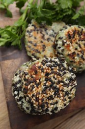 Delicious vegan cutlets with sesame and fresh parsley on wooden table, closeup