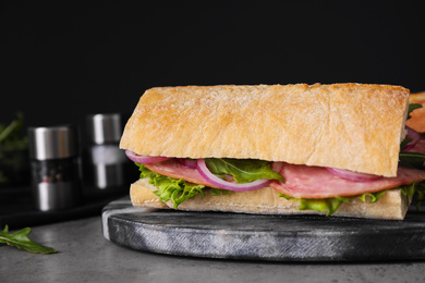 Photo of Tasty sandwich with ham on grey table, closeup