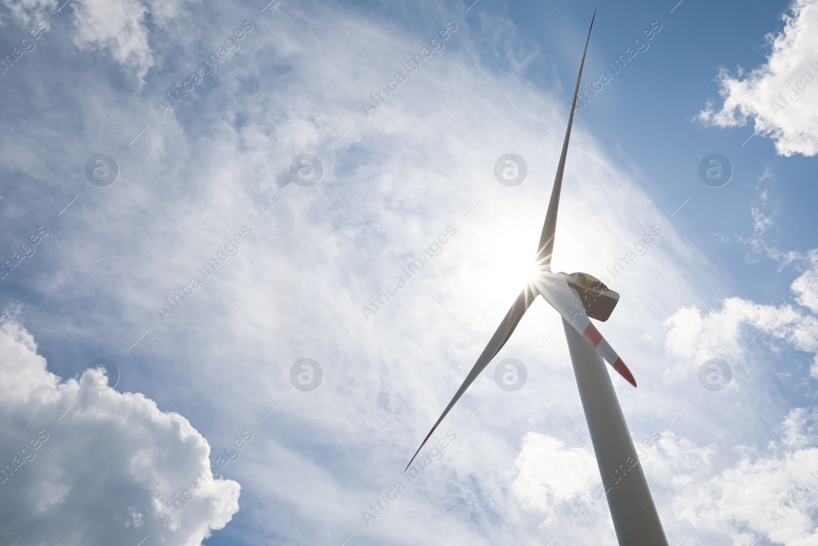 Photo of Modern wind turbine against cloudy sky, low angle view. Alternative energy source