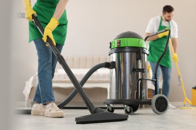 Photo of Professional janitors working in bedroom, closeup. Cleaning service