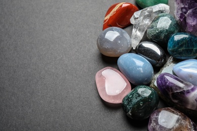 Photo of Flat lay composition with different gemstones on dark table, space for text