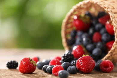 Photo of Different fresh ripe berries on wooden table outdoors, closeup