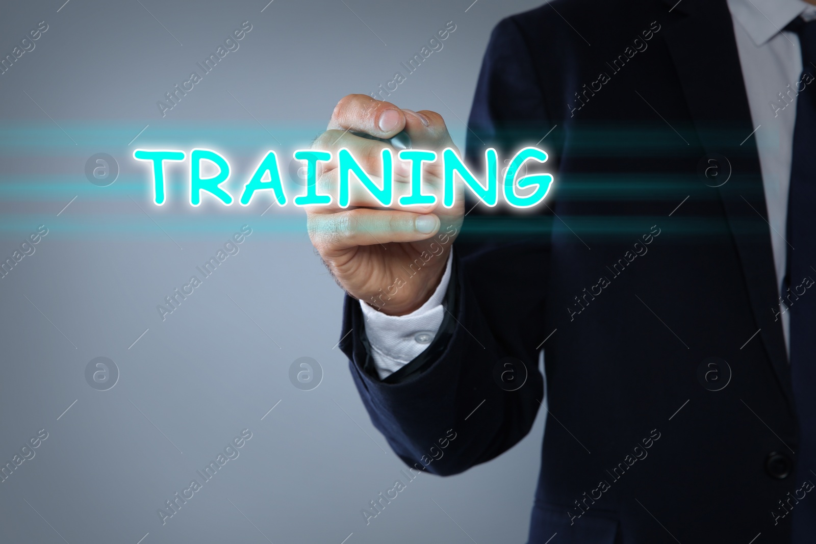 Image of Businessman pointing at virtual screen with inscription TRAINING on light background, closeup 