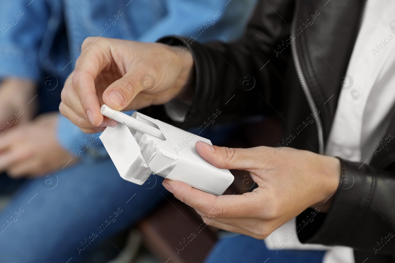 Photo of Woman taking cigarette out of pack outdoors, closeup