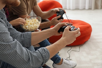 Group of friends playing video games at home, closeup