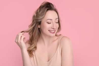 Portrait of smiling woman on pink background