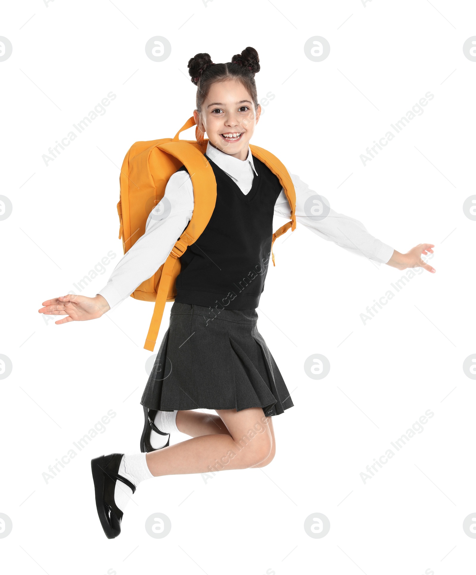 Photo of Happy girl in school uniform jumping on white background