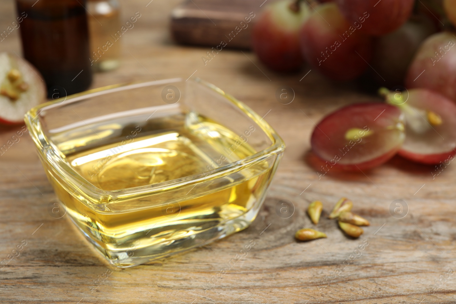 Photo of Natural grape seed oil on wooden table. Organic cosmetic