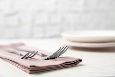 Photo of Cutlery set and dishware on white wooden table