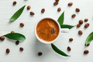 Photo of Flat lay composition with cup of aromatic hot coffee and beans on wooden background