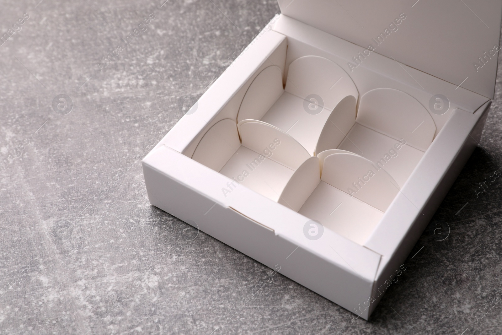 Photo of Empty white box for candies on light grey table, closeup