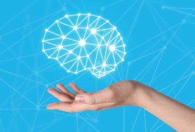 Image of Memory. Woman holding illustration of brain against light blue background with scheme, closeup