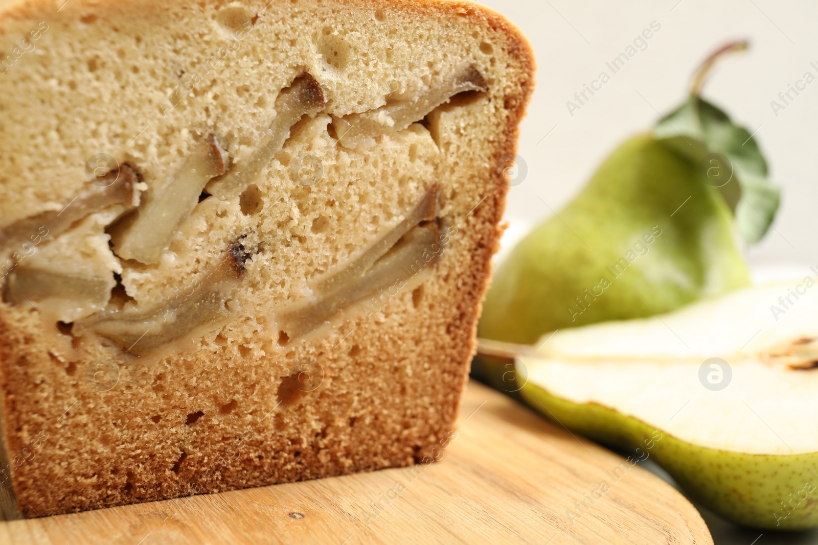 Photo of Tasty pear bread on wooden board, closeup. Homemade cake