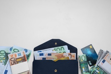Photo of Wallet, different Euro banknotes and credit card on white table, flat lay with space for text. Money exchange
