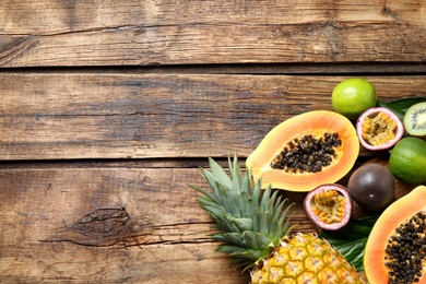 Photo of Fresh ripe papaya and other fruits on wooden table, flat lay. Space for text