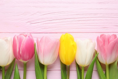 Photo of Flat lay composition of beautiful spring tulips on wooden background, space for text. International Women's Day