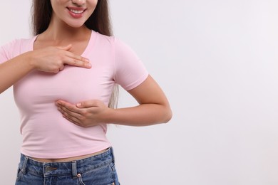 Photo of Woman doing breast self-examination on white background, closeup. Space for text