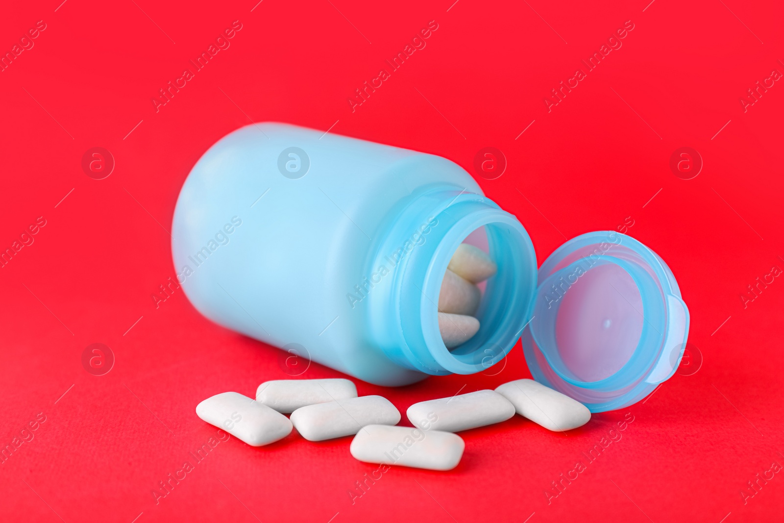 Photo of Jar with chewing gums on red background