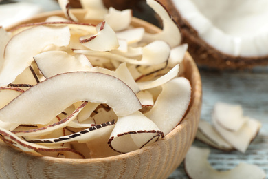 Tasty coconut chips in wooden bowl, closeup