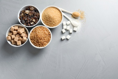 Flat lay composition with different types of sugar on gray background