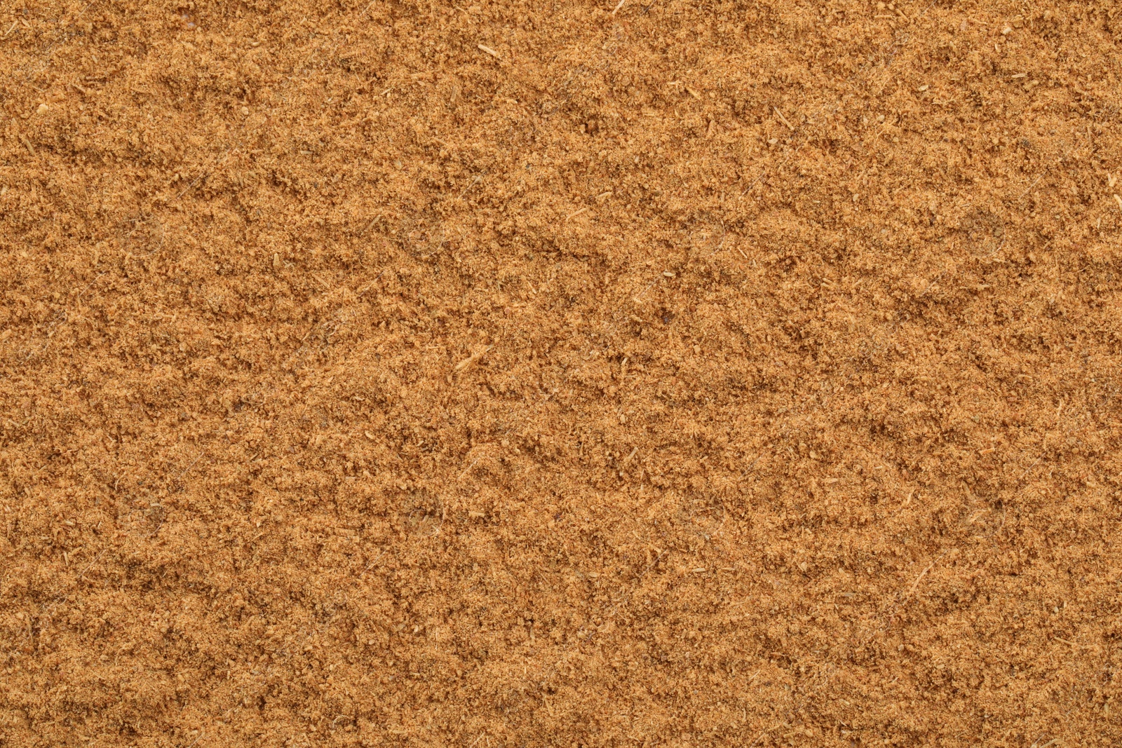 Photo of Dry aromatic cinnamon powder as background, top view