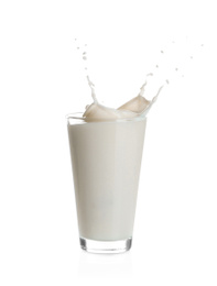 Photo of Milk splashing out of glass isolated on white
