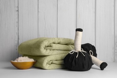 Photo of Composition with spa products on white table against wooden background