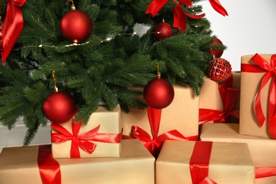 Decorated Christmas tree and gift boxes on light background, closeup