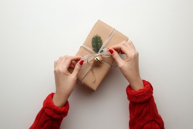 Photo of Woman holding Christmas gift box on white background, top view