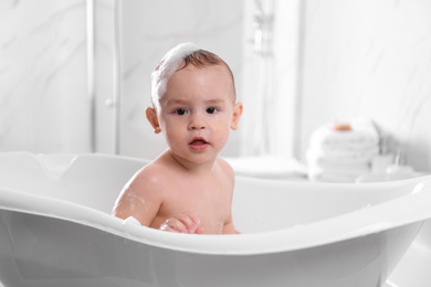 Photo of Cute little baby in bathtub at home